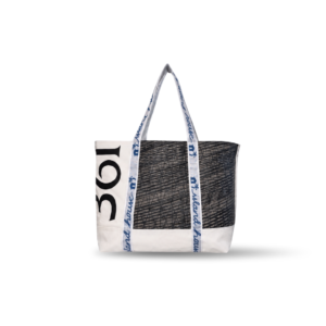 The front of a large tote made of white reclaimed sailcloth. The straps are made of sail tie webbing and are white with navy blue lettering that reads "Island House". The sailcloth features original black and gray markings, with the number 361.