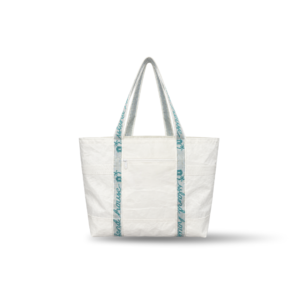 The front of a large tote made of plain white reclaimed sailcloth. The straps are made of sail tie webbing and are white with aqua blue lettering that reads "Island House".