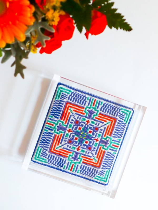 a colorful mandala needlepoint finished as an acrylic tray